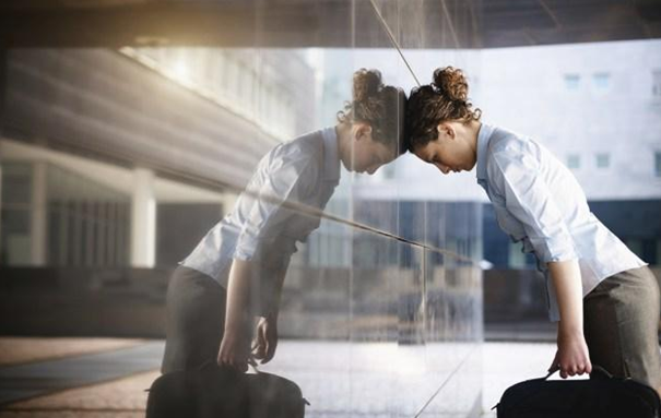 Person leaning against glass showing emotional overwhelm and internal pressure linked to procrastination