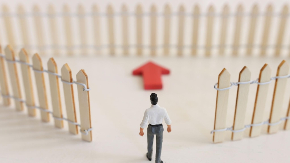 person walking through open fence symbolizing breaking limiting beliefs and moving forward in life