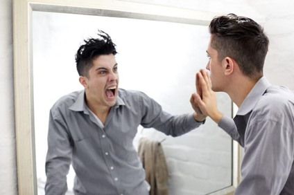 self discipline and inner conflict represented by man confronting himself in mirror