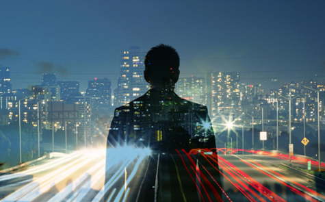 Silhouetted person overlaid with a city skyline and traffic light trails