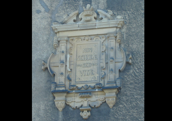 Ornate wall plaque inscribed “Non scholae sed vitae”